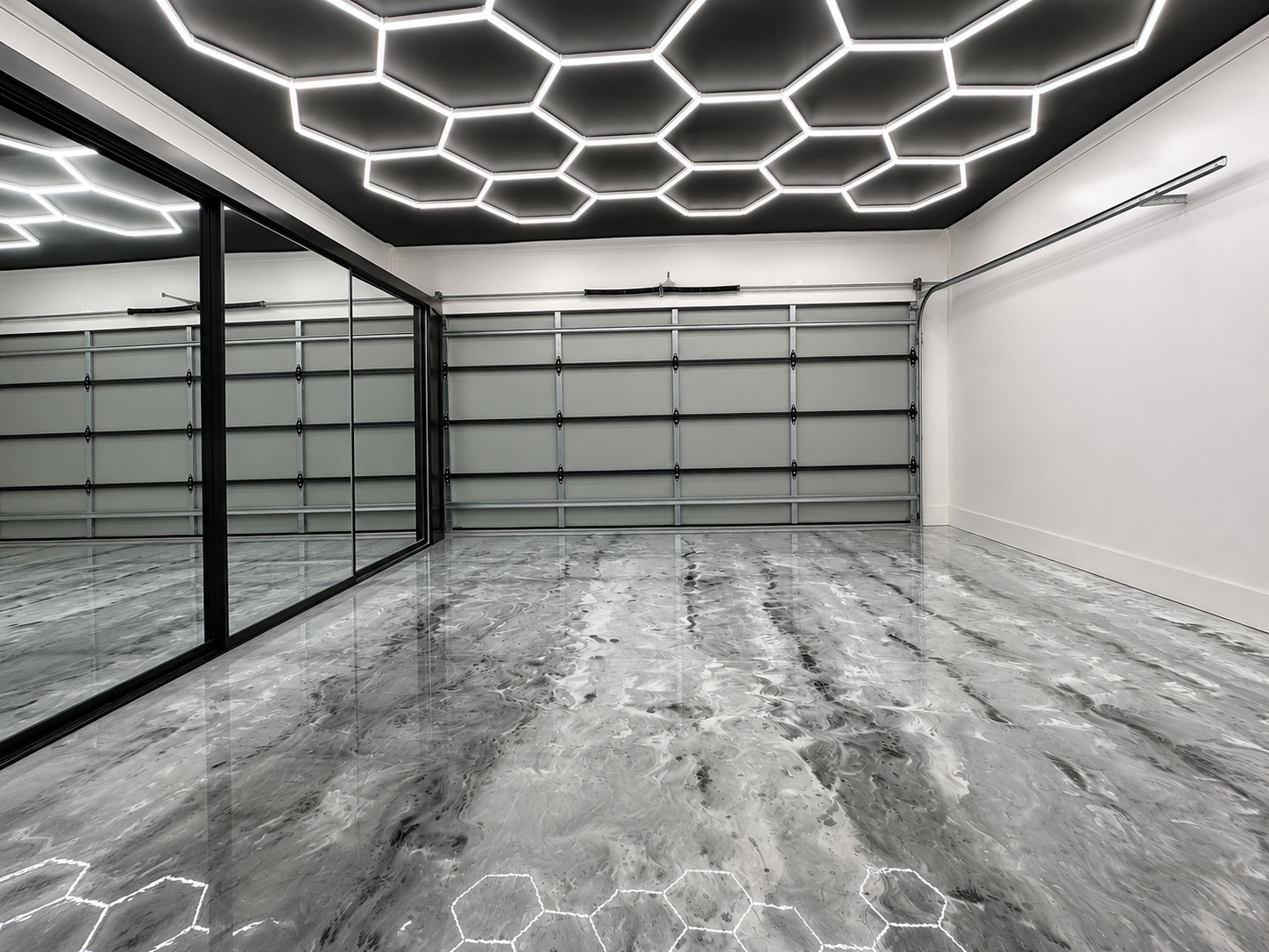 Glossy grey garage floor beneath geometric lighting