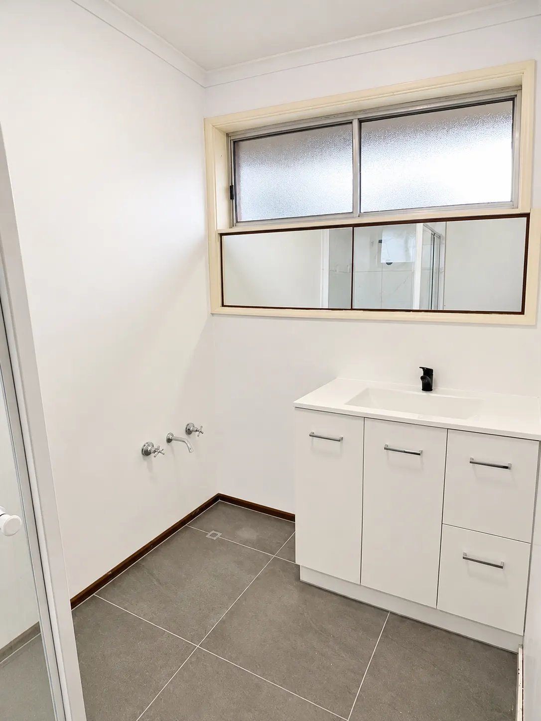 Bathroom vanity and tiled floor ready for a renovation finish