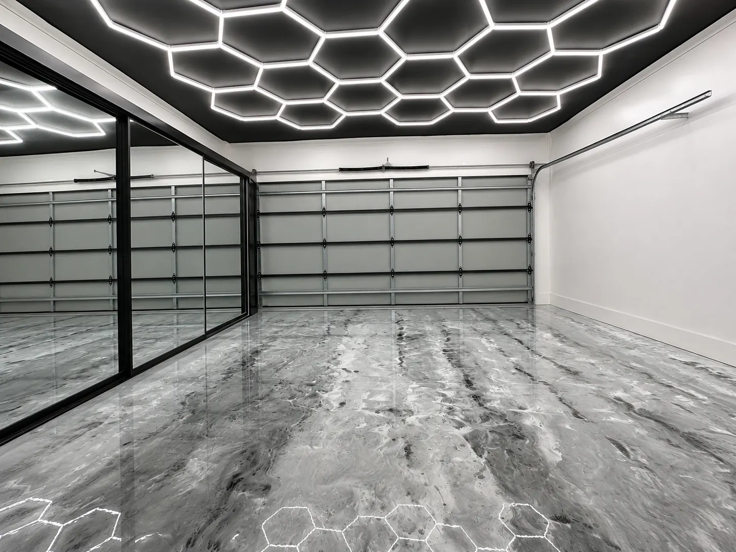 Glossy grey garage floor beneath geometric lighting