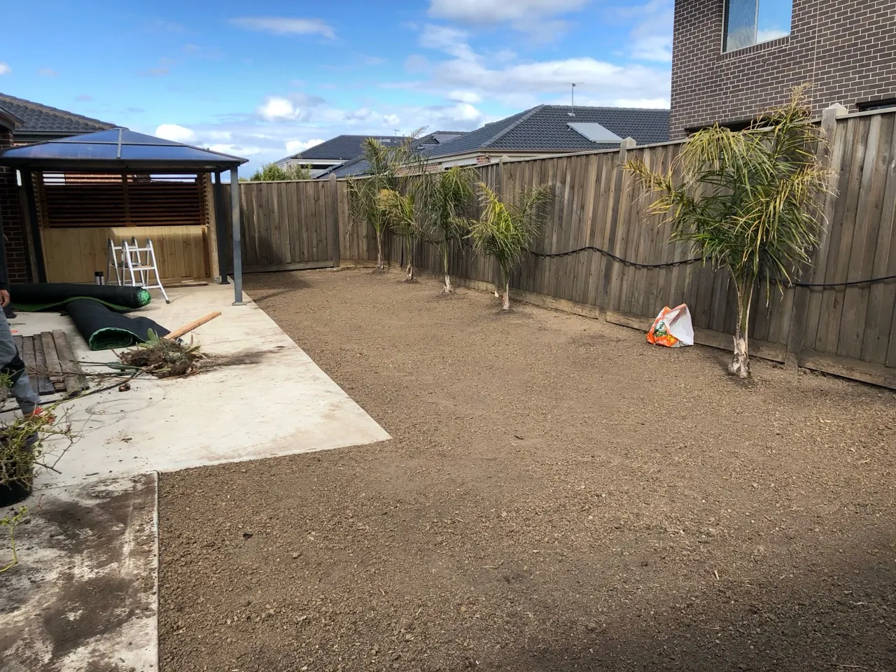 Backyard with prepared ground before the lawn and privacy screening were completed