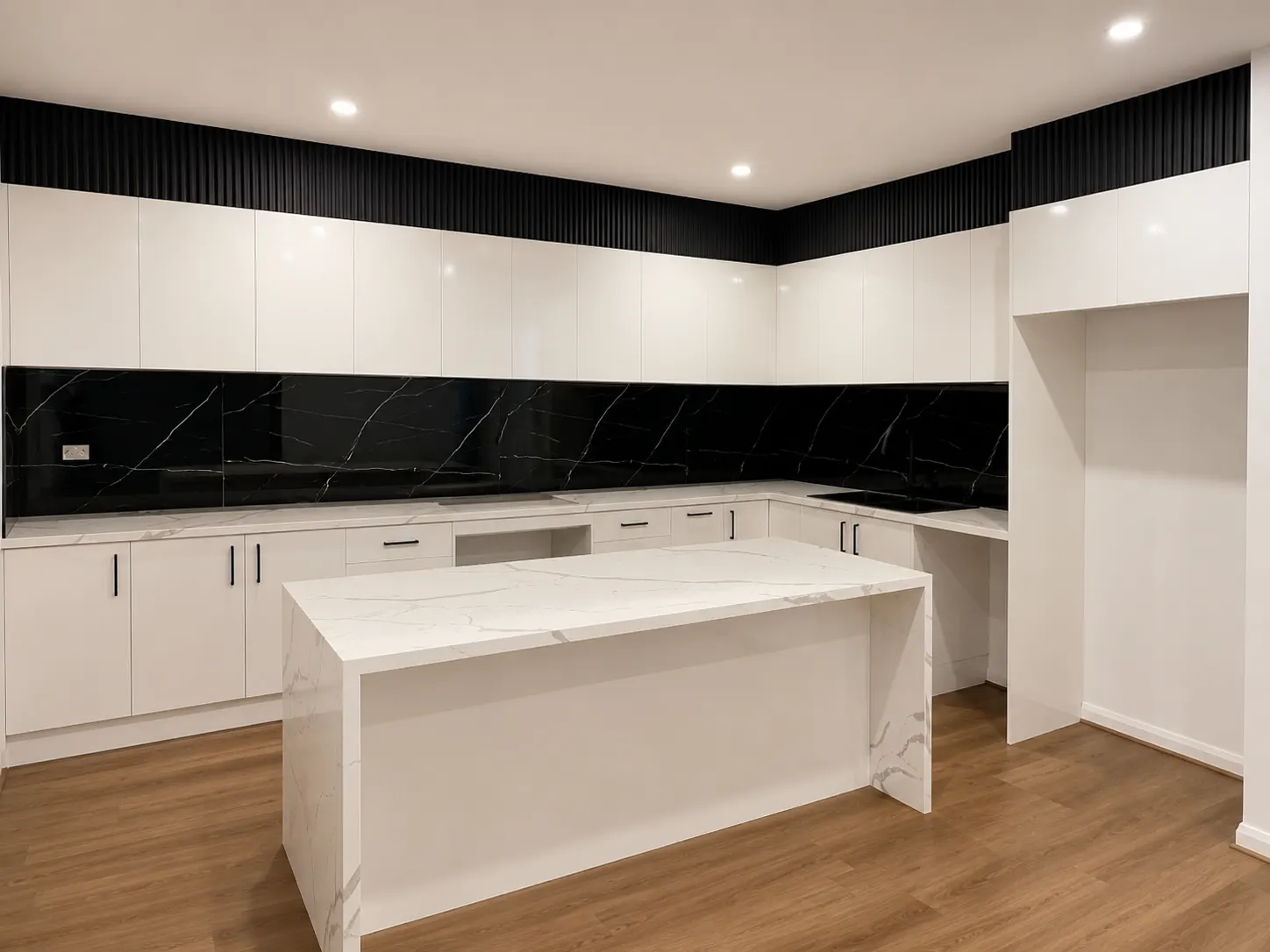 White kitchen with black stone splashback and large island